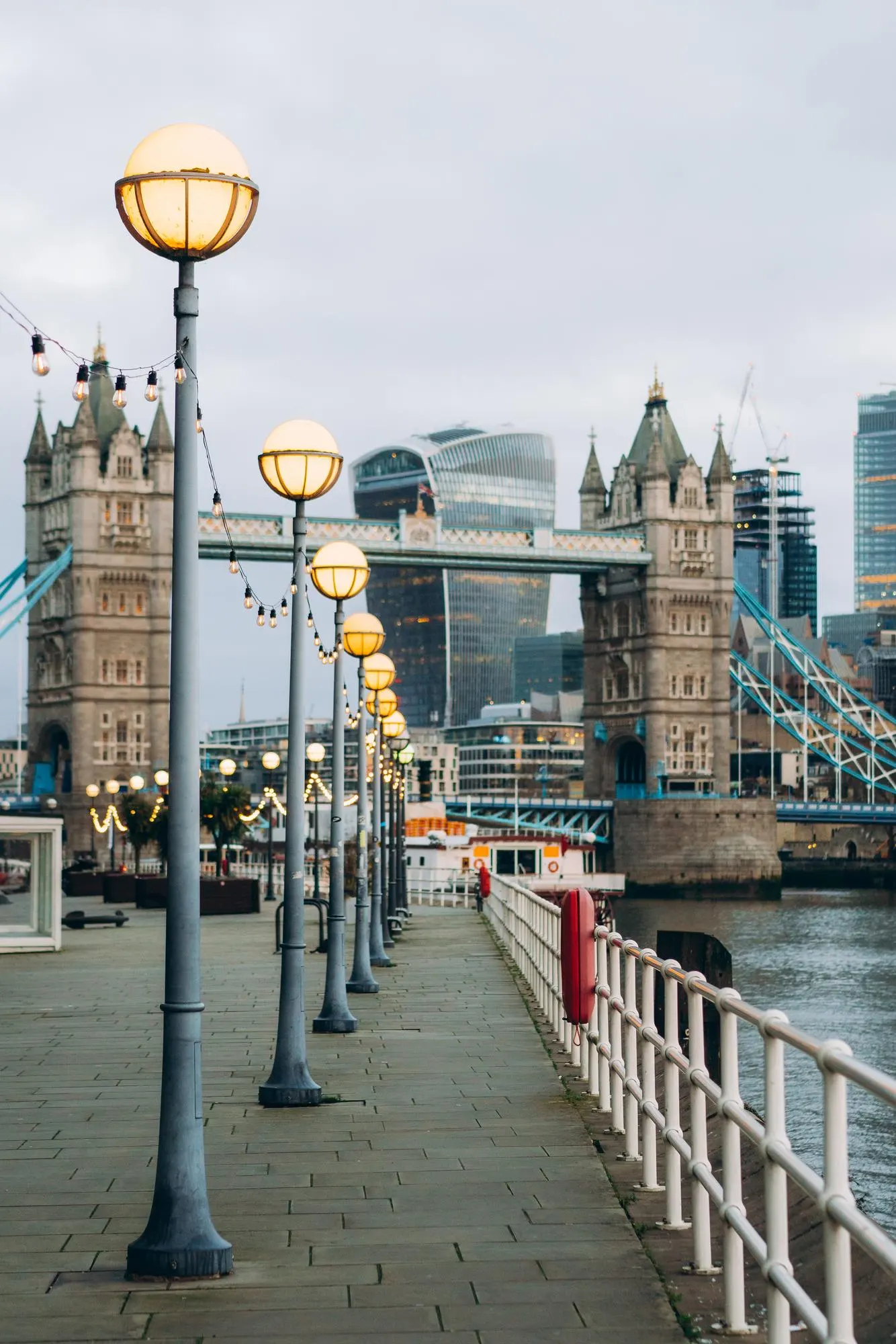 The Thames riverside at dusk beneath Tower Bridge